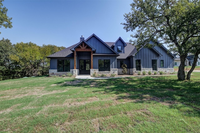 view of front facade featuring french doors, board and batten siding, a chimney, and a front lawn