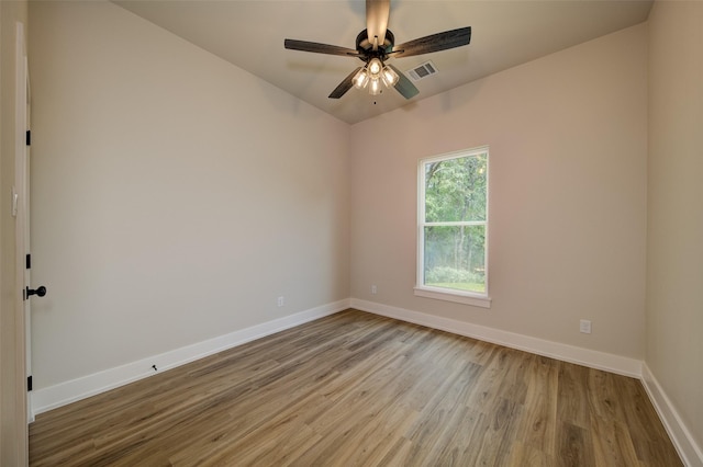 empty room featuring baseboards, a ceiling fan, wood finished floors, and visible vents