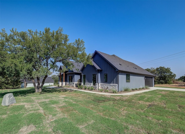 view of side of home featuring a lawn, a garage, board and batten siding, and driveway