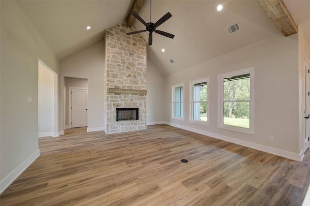 unfurnished living room with visible vents, beam ceiling, high vaulted ceiling, light wood-type flooring, and a ceiling fan