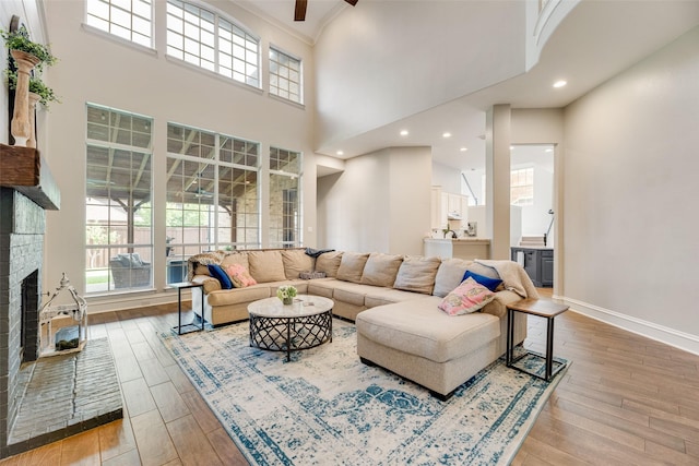 1355 Crockett Dr, Frisco, TX 75033 - living area featuring a towering ceiling, hardwood / wood-style floors, ceiling fan, a fireplace, and baseboards
