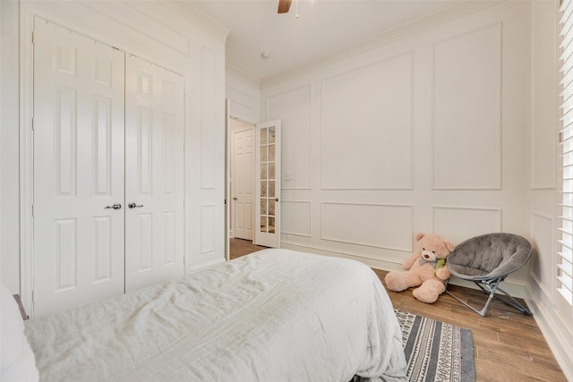 1355 Crockett Dr, Frisco, TX 75033 - bedroom featuring a decorative wall, crown molding, wood finished floors, a closet, and a ceiling fan