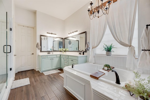 1355 Crockett Dr, Frisco, TX 75033 - bathroom featuring a bath, a stall shower, double vanity, a chandelier, and wood finished floors