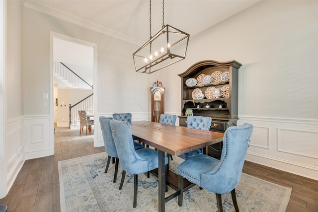 1355 Crockett Dr, Frisco, TX 75033 - dining space featuring a chandelier, crown molding, a wainscoted wall, dark wood-style floors, and a decorative wall