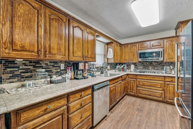 372 County Road 477, Stephenville, TX 76401 - kitchen with a sink, stainless steel appliances, brown cabinets, and a textured ceiling