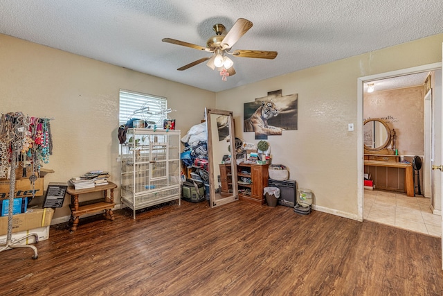 372 County Road 477, Stephenville, TX 76401 - interior space with ceiling fan, a textured wall, a textured ceiling, baseboards, and wood finished floors
