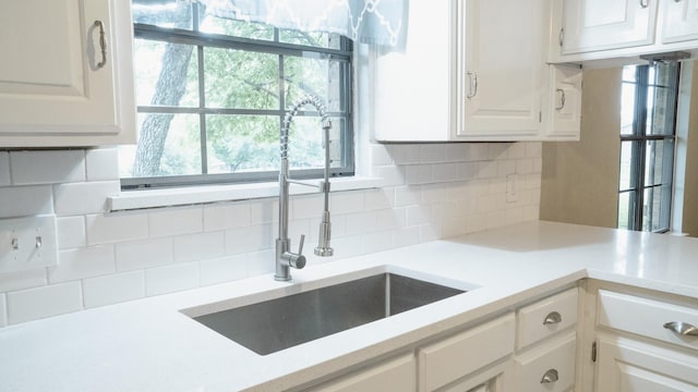 75 Delmore Dr, Hillsboro, TX 76645 - kitchen with a sink, light countertops, white cabinetry, and backsplash