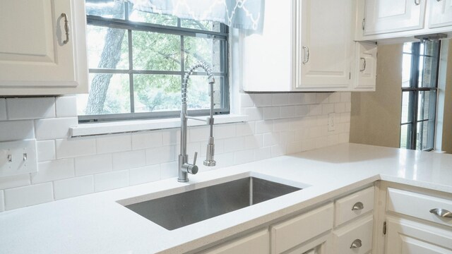 75 Delmore Dr, Hillsboro, TX 76645 - kitchen with a sink, light countertops, white cabinetry, and backsplash