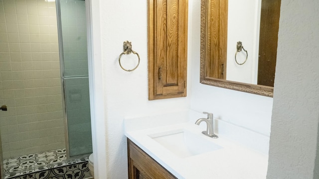 full bathroom featuring vanity, a shower stall, and toilet