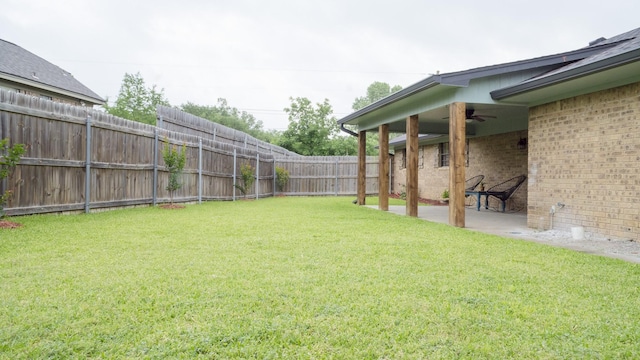 view of yard with a patio, a ceiling fan, and a fenced backyard