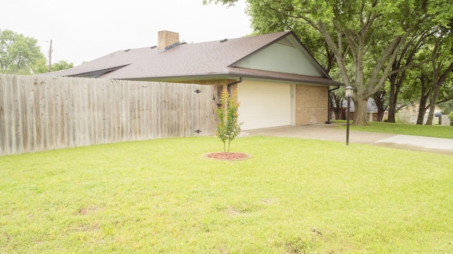 view of side of property featuring a lawn, fence, driveway, and a chimney