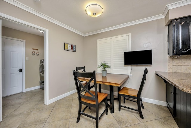 dining area featuring crown molding, baseboards, light tile patterned floors, and washer / dryer