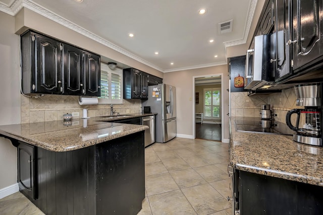 kitchen featuring dark cabinets, a sink, visible vents, and tasteful backsplash