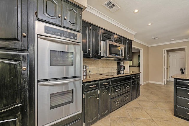 kitchen with stainless steel appliances, visible vents, decorative backsplash, and dark cabinets