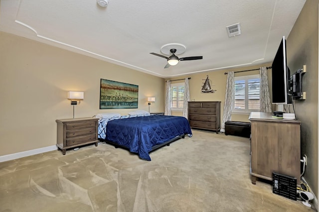 bedroom featuring light colored carpet, a textured ceiling, a ceiling fan, baseboards, and visible vents