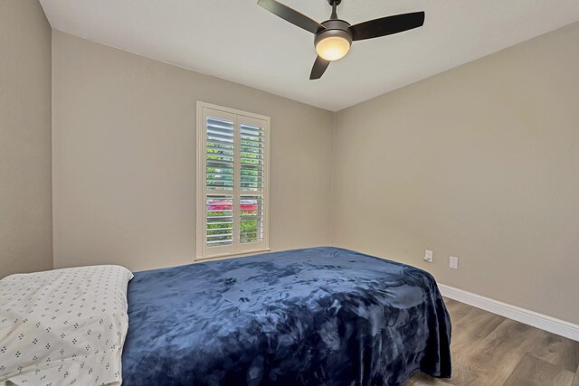 bedroom with baseboards, a ceiling fan, and wood finished floors