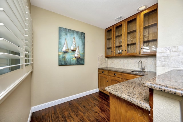 bar with visible vents, baseboards, a sink, dark wood finished floors, and backsplash
