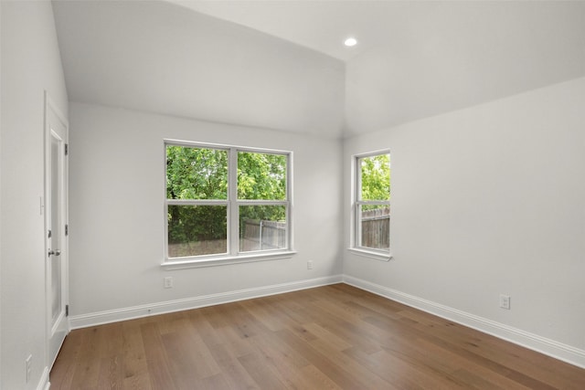 unfurnished room featuring baseboards, recessed lighting, wood finished floors, and vaulted ceiling