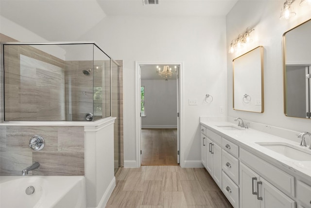 full bath with double vanity, a sink, a garden tub, and a stall shower