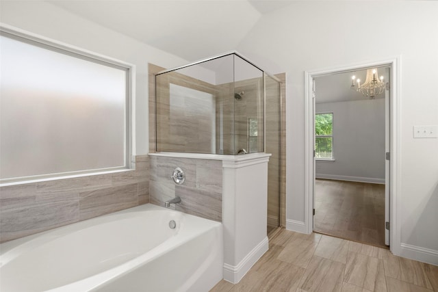 bathroom with baseboards, a bath, a chandelier, and a shower stall