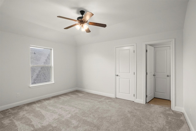 unfurnished bedroom with baseboards, carpet flooring, a ceiling fan, and vaulted ceiling