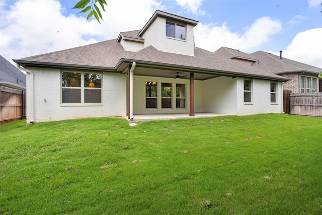 back of house with a fenced backyard, a ceiling fan, a shingled roof, and a yard