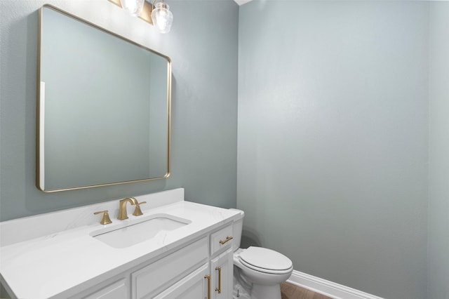 bathroom featuring vanity, baseboards, toilet, and wood finished floors