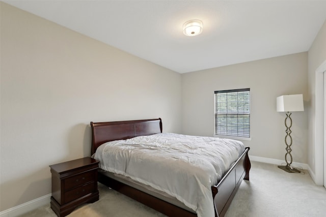 bedroom featuring baseboards and light carpet