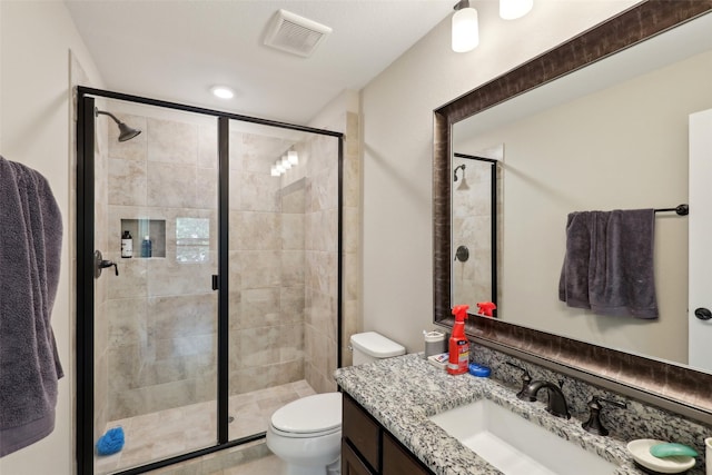 full bath with vanity, a shower stall, toilet, and visible vents