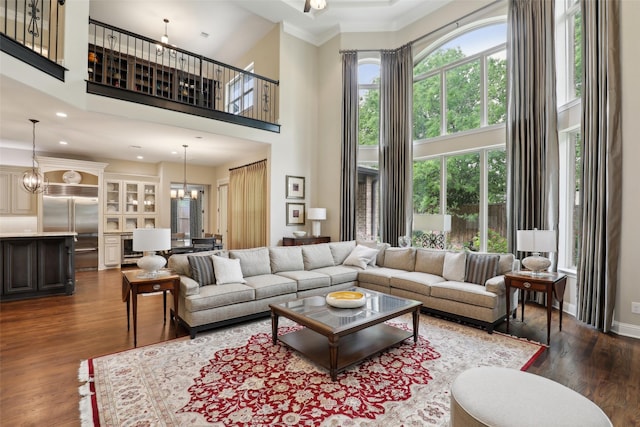 living area featuring crown molding, recessed lighting, a high ceiling, and dark wood finished floors