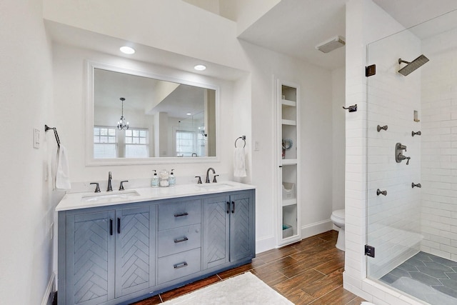 bathroom featuring a sink, a stall shower, wood finished floors, and a chandelier