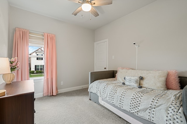 bedroom with light colored carpet, baseboards, and ceiling fan