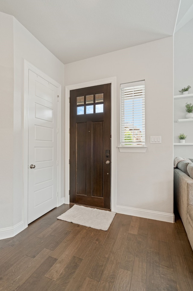 entryway featuring baseboards and dark wood finished floors