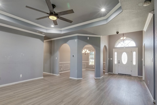 18055 Langford Ln, Talty, TX 75126 - foyer entrance with crown molding, arched walkways, ceiling fan with notable chandelier, wood finished floors, and a tray ceiling