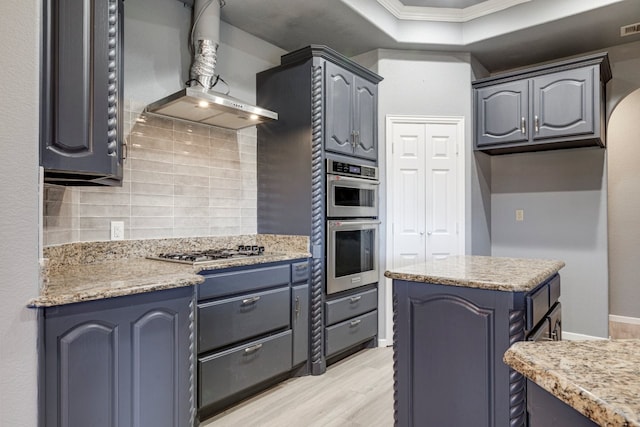 18055 Langford Ln, Talty, TX 75126 - kitchen featuring crown molding, wall chimney range hood, a tray ceiling, light wood-style flooring, and appliances with stainless steel finishes