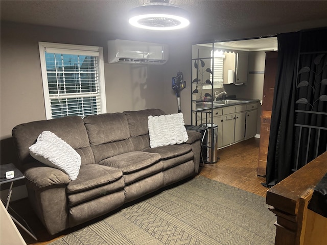living area with an AC wall unit and wood finished floors