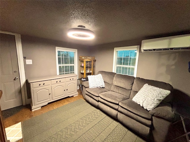 living room with a wall mounted AC, light wood-style flooring, and a textured ceiling