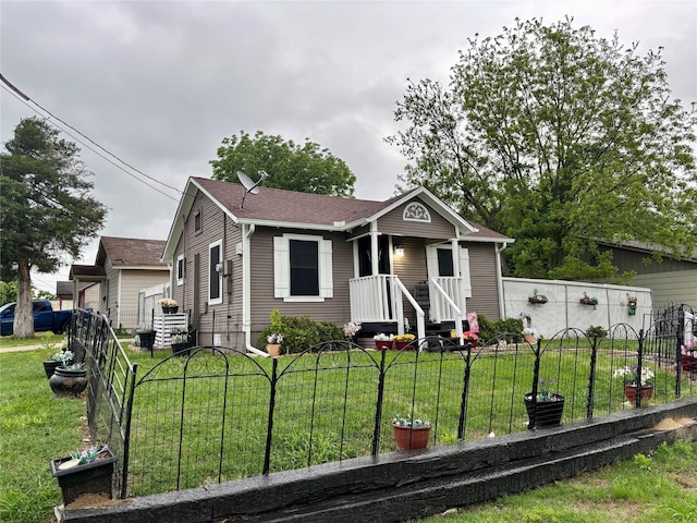 bungalow-style home with fence and a front lawn