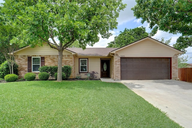 ranch-style home featuring fence, a front yard, brick siding, concrete driveway, and an attached garage