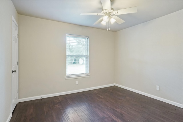 empty room featuring a ceiling fan, baseboards, and dark wood-type flooring