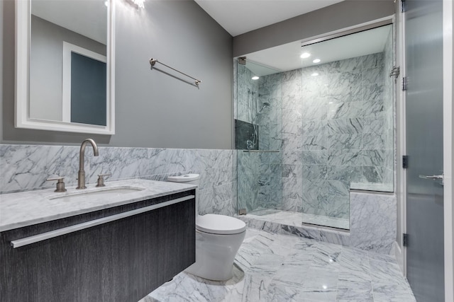 bathroom with vanity, wainscoting, toilet, tile walls, and a marble finish shower