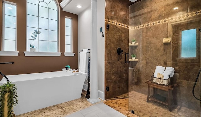 bathroom with a freestanding bath, plenty of natural light, walk in shower, and ornate columns