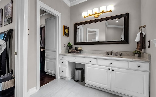 bathroom with crown molding, baseboards, and vanity