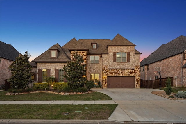 6380 Forefront Ave, Frisco, TX 75036 - french country home with driveway, an attached garage, brick siding, stone siding, and a shingled roof