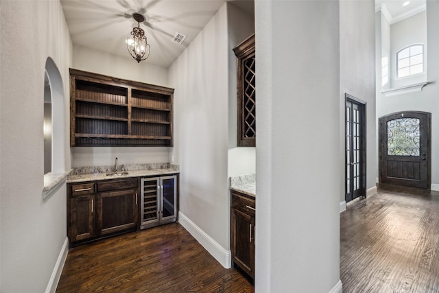 6380 Forefront Ave, Frisco, TX 75036 - indoor bar featuring wine cooler, dark wood-style flooring, baseboards, crown molding, and arched walkways