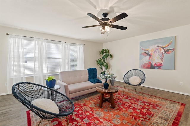 living room with baseboards, ceiling fan, and wood finished floors