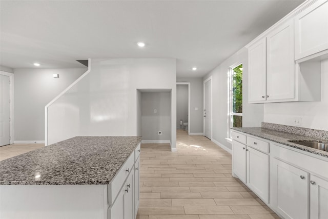 2021 Eva St, Grand Prairie, TX 75051 - kitchen featuring a center island, baseboards, white cabinets, dark stone countertops, and recessed lighting