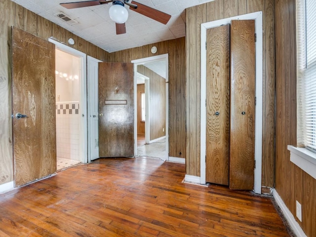 interior space with wood walls and hardwood / wood-style flooring
