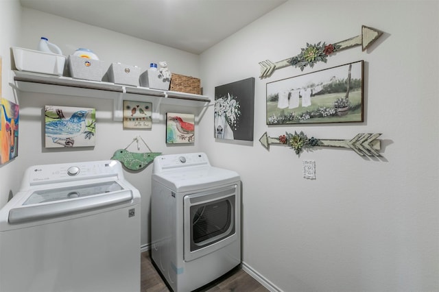 washroom featuring washer and dryer, laundry area, dark wood finished floors, and baseboards