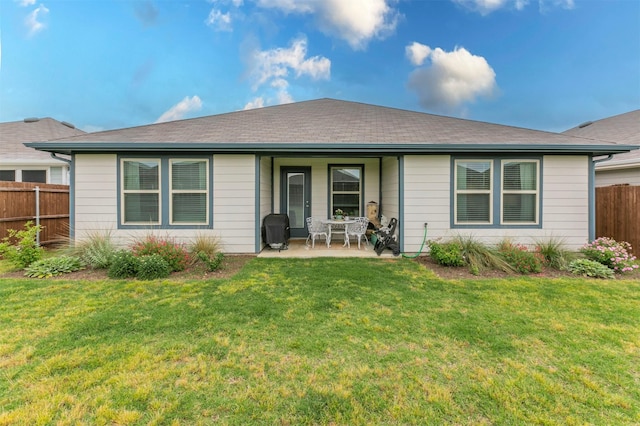 back of property featuring fence, a yard, and a patio area